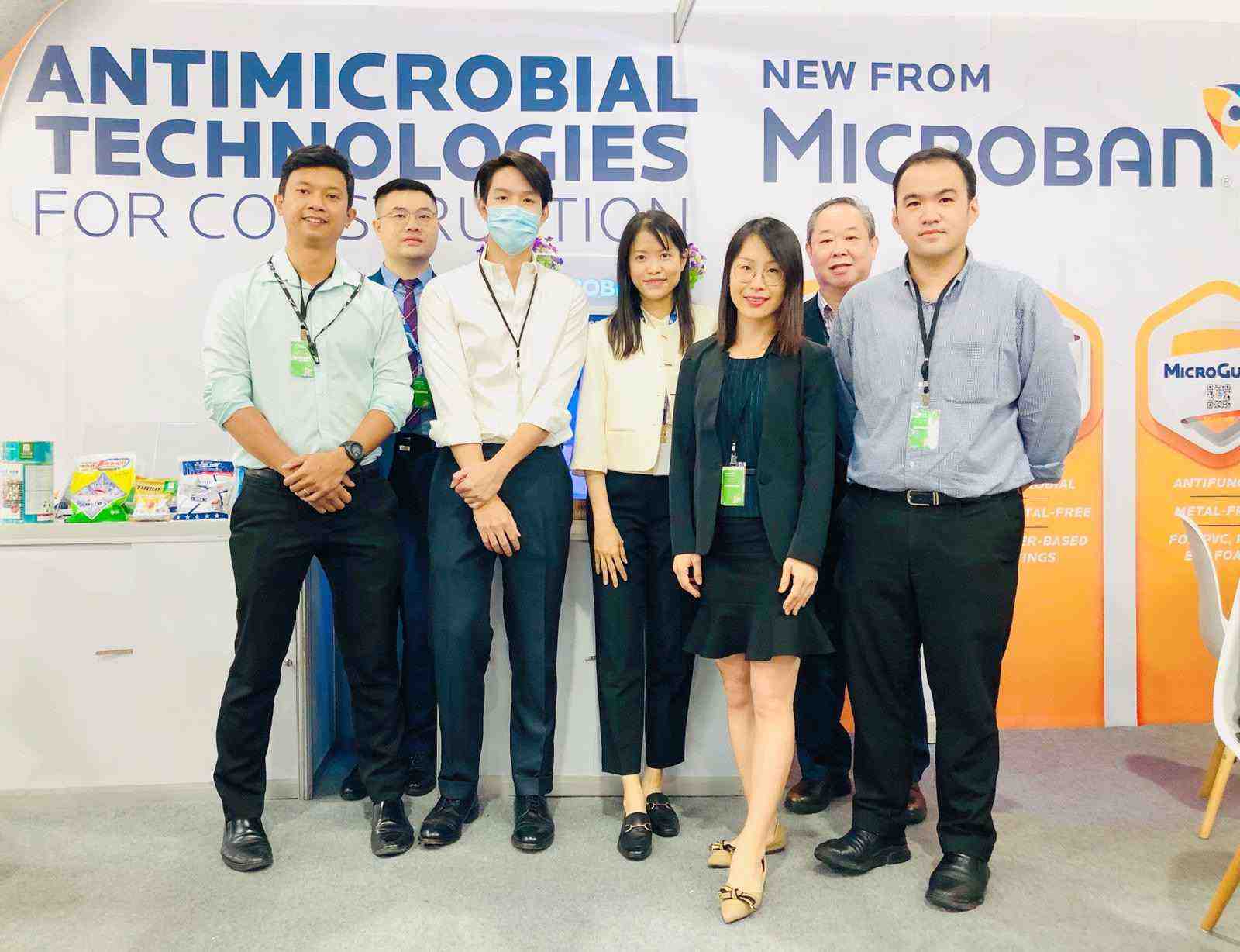 Microban International team members stand in a line in front of their booth at the Architect Expo in Bangkok, Thailand.